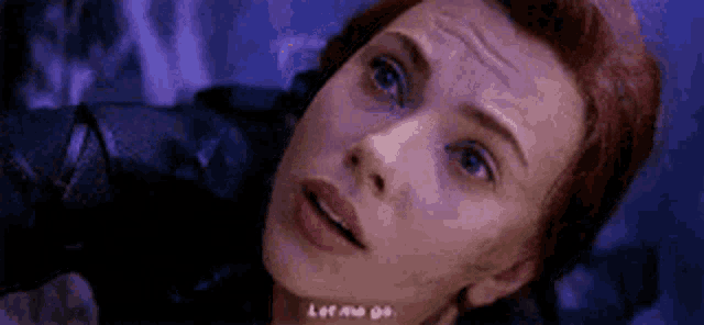a close up of a woman 's face with a purple background and the words `` let me go '' .