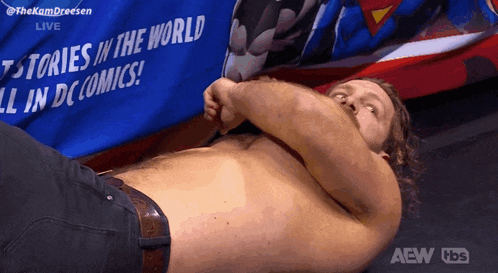 a shirtless man is laying in front of a banner that says stories in the world all in dc comics