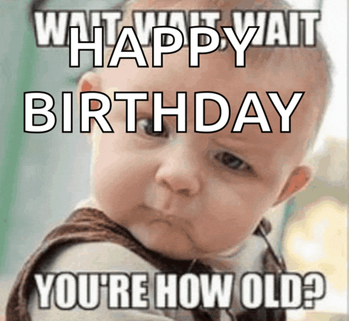 a baby is holding a sign that says what wait wait happy birthday you 're how old ?