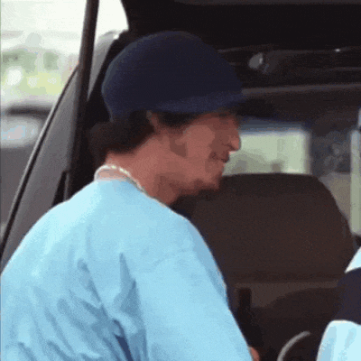 a man wearing a baseball cap is sitting in the back of a car
