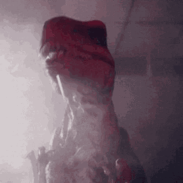 a close up of a dinosaur 's head with smoke coming out of its mouth