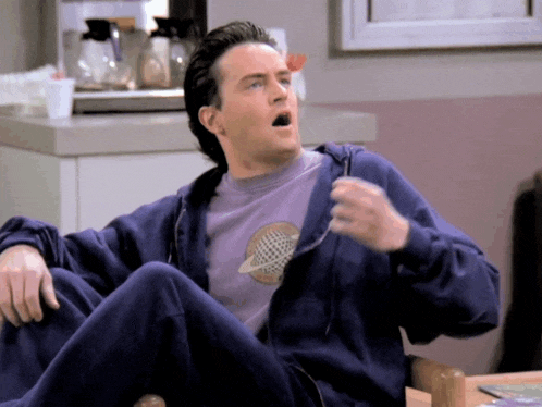 a man wearing a blue hoodie and a purple shirt with a planet on it