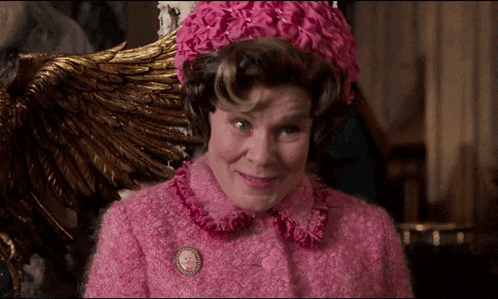 a woman wearing a pink jacket and a pink hat with flowers on it