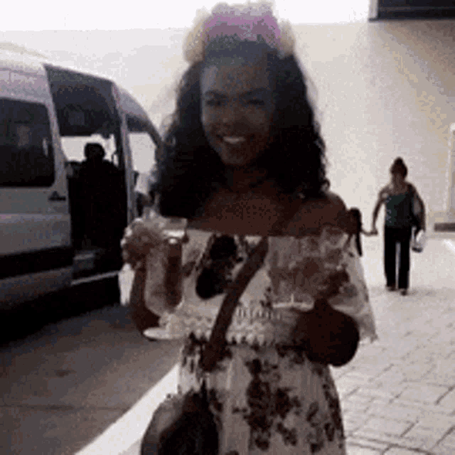 a woman wearing a flower crown holds a glass of wine