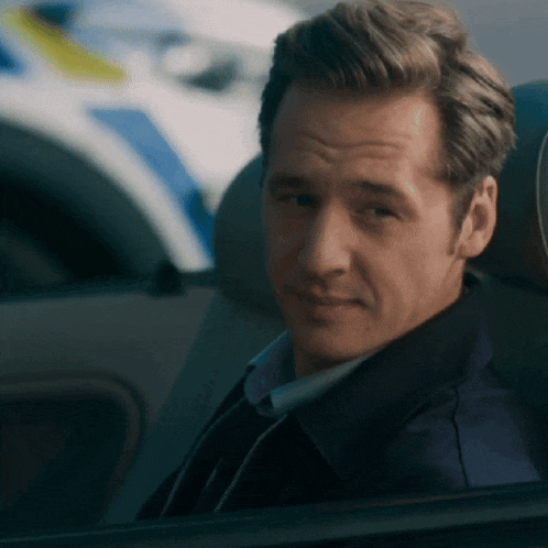 a man sitting in a car looking out the window
