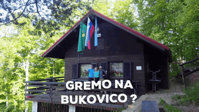 a group of people standing in front of a small house with the words gremo na bukovico