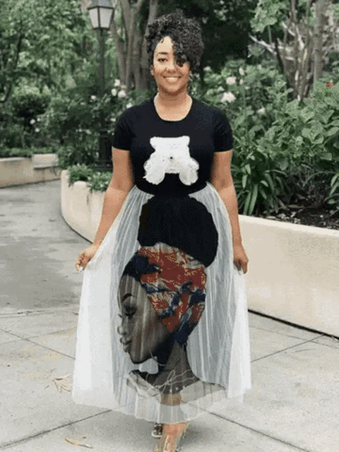 a woman wearing a black shirt with a teddy bear on it and a white tulle skirt