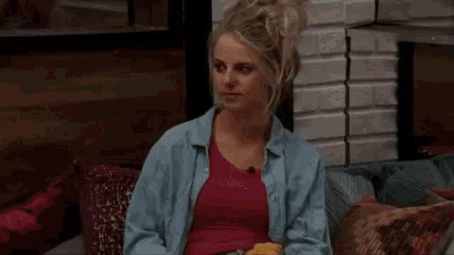 a woman is sitting on a couch with her hands in the air .