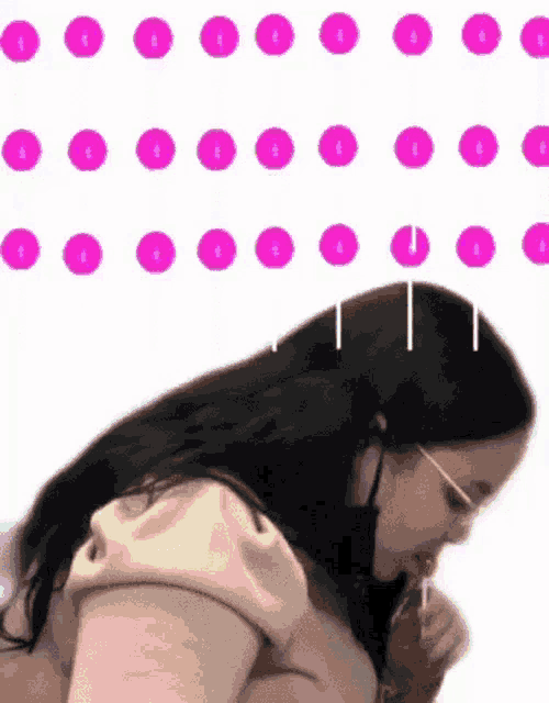 a woman is eating a lollipop with pink polka dots behind her