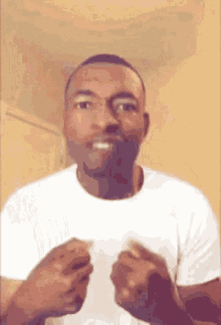 a man in a white shirt is making a funny face with his hands in the air .