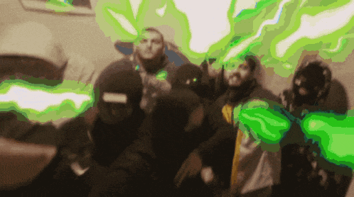 a group of people are posing for a picture with green smoke coming out of their faces