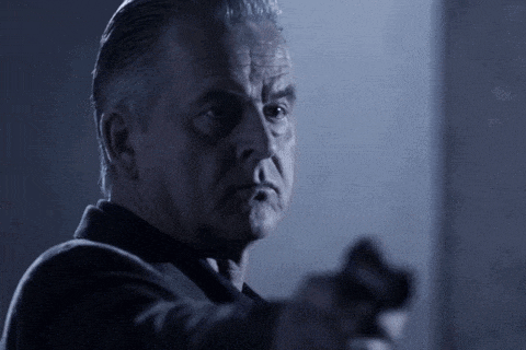 a man is pointing a gun at something in the dark