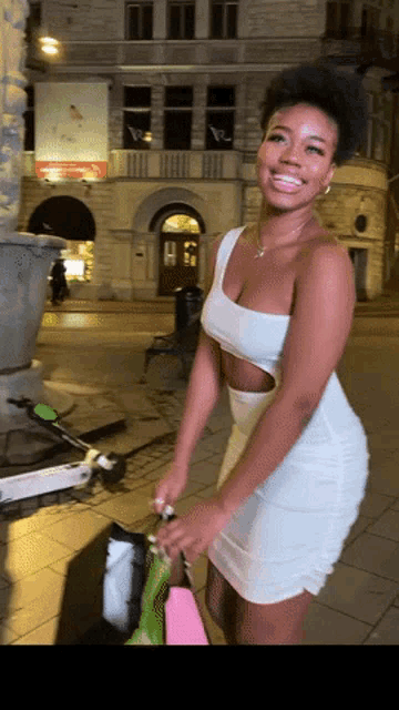 a woman in a white dress holds a pink bag