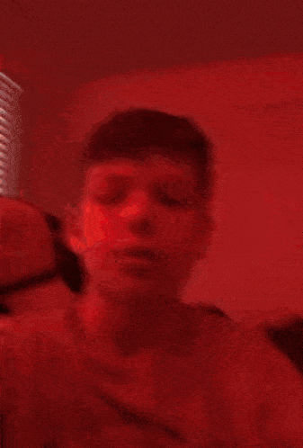 a close up of a person 's face in a red room .