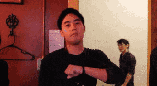 a man in a black shirt is looking at his wristwatch