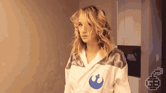 a woman is wearing a robe with a star wars logo on the front