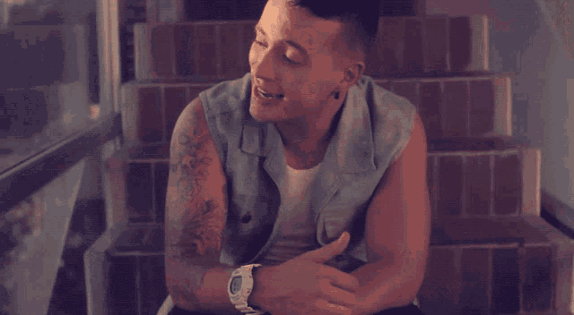 a man with a tattoo on his arm is smiling