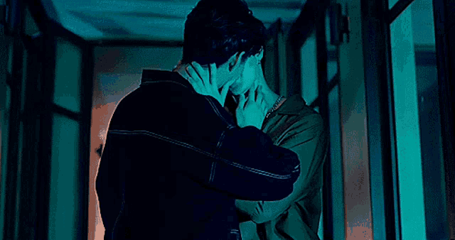 a man and a woman are kissing in a hallway .