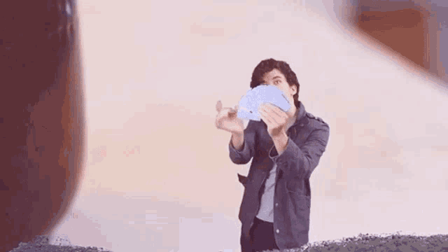 a man in a suit is holding a fan of playing cards and the words pick a card are above him