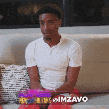 a young man sits on a couch with the words new orleans @imzavo on the bottom