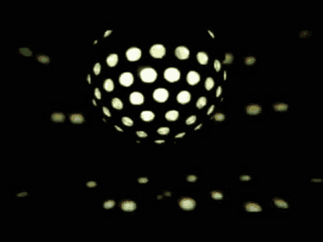 a disco ball with dots on it is spinning in the dark