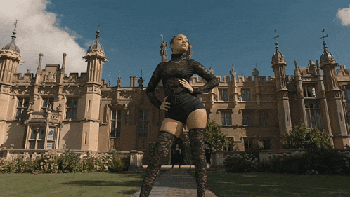 a woman standing in front of a castle with a sign that says ' a '