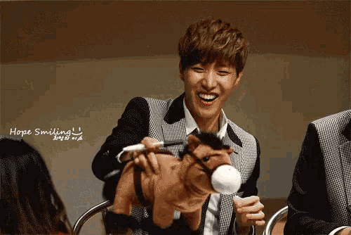 a young man is smiling while holding a stuffed horse with the words hope smiling written above him
