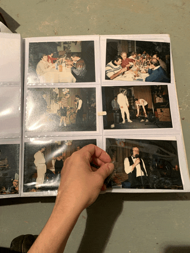 a person is holding a photo album filled with many pictures
