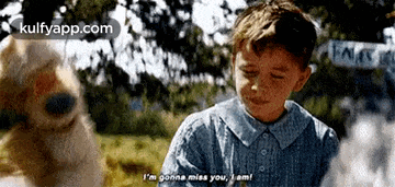 a young boy is standing next to a dog and saying i 'm gonna miss you .