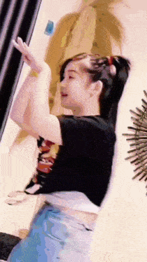 a woman is dancing in a room with her arms outstretched .