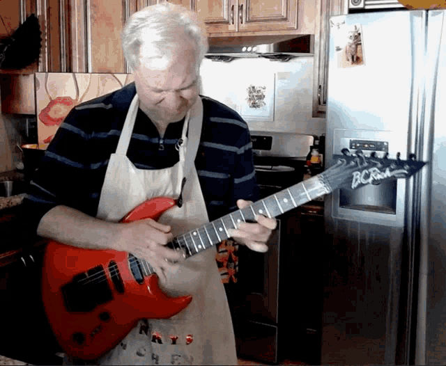 a man in an apron is playing a red bcrich electric guitar