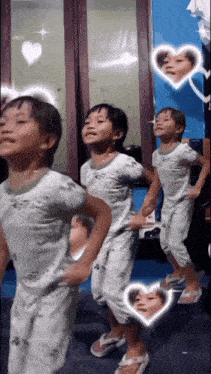three little girls are dancing in front of a mirror with hearts around them