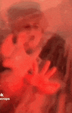 a blurry picture of a person with a red light behind them that says " crops "