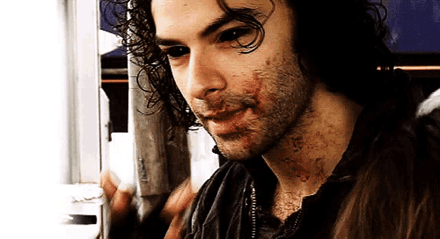 a man with blood on his face is looking at the camera