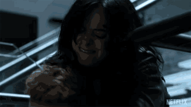 a woman in a dark room with a netflix logo on the bottom right