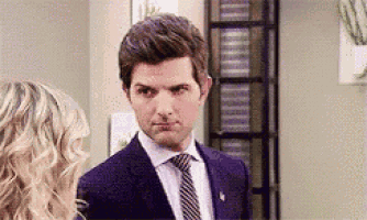 a man in a suit and tie is standing in front of a woman .