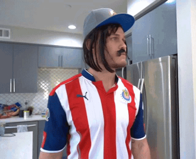 a man wearing a red white and blue striped shirt with a puma logo on the front