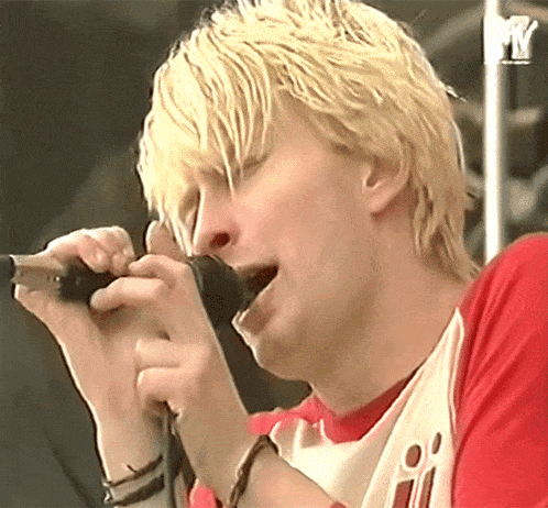 a close up of a person singing into a microphone