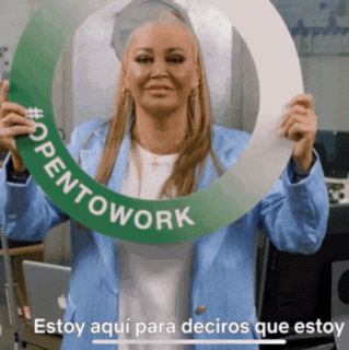 a woman in a blue jacket is holding a green sign that says opentowork