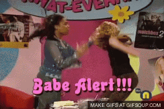 two girls are dancing in front of a sign that says babe alert !!!