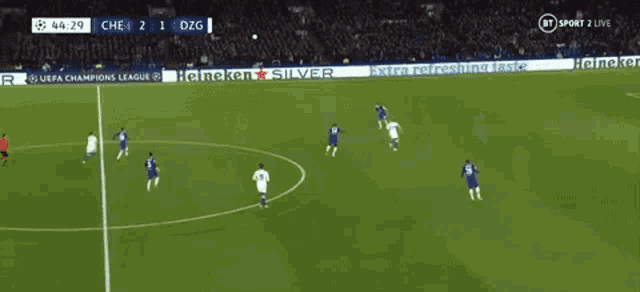a soccer game is being played in front of a heineken silver ad