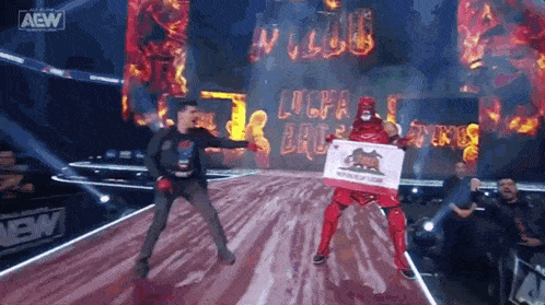 a wrestler is holding a california flag while standing next to a man on a stage .