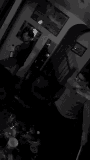 a black and white photo of people standing around a table in a living room