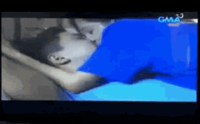 a man and woman kissing on a television screen .
