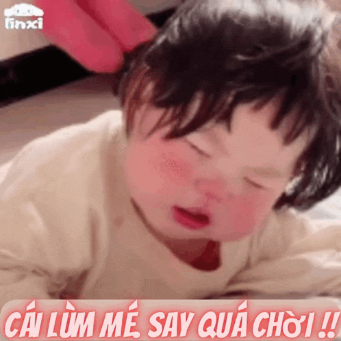 a baby is laying on a bed with chinese writing on the bottom of it