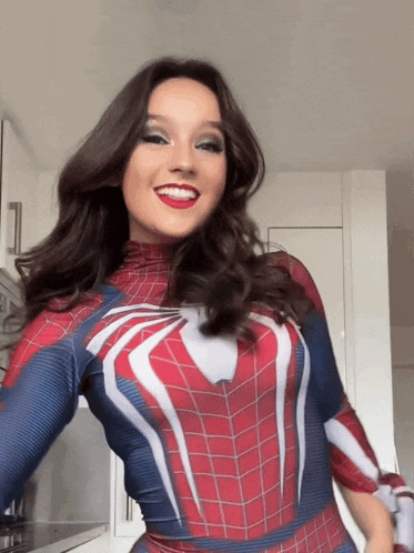 a woman in a spiderman costume is smiling and looking at the camera