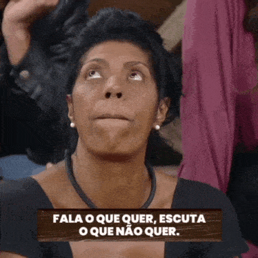 a woman looking up with a sign that says fala o que quer