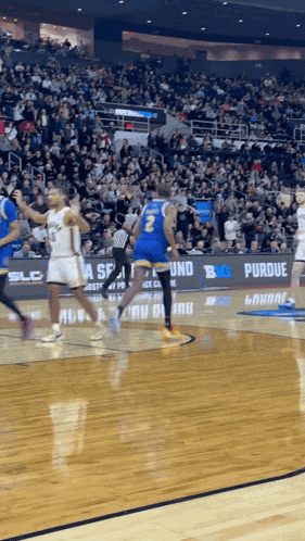 a basketball game is being played in front of a large crowd