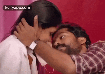 a man and a woman are kissing each other in a room .