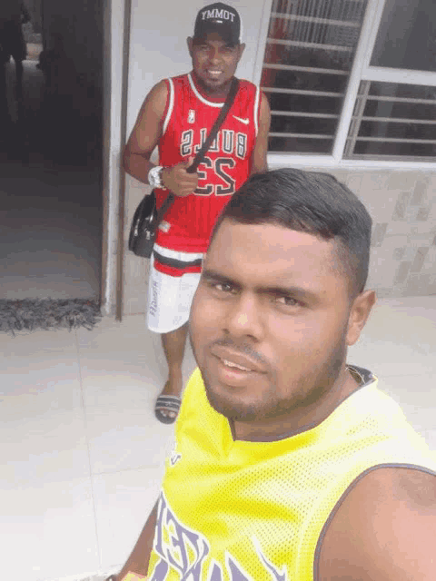 two men are posing for a picture one is wearing a bulls jersey